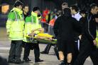 Oxford United assistant manager Mickey Lewis (back to camera) looks on as Peter Leven is stretchered off at Northampton on Friday night – but the midfielder’s injury may not be as serious as first feared