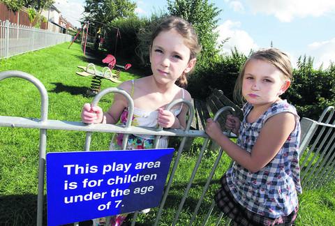 Seven-year-old Jazmine Selby, right, who is unable to join her friend, Caja Jennings, six, in the play area in Milton Heights