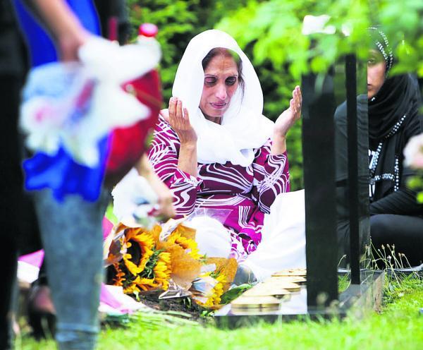 Mehfooz Akhtar at the graves of her children Anum and Majid at Botley Cemetery yesterday       Picture: Damian Halliwell