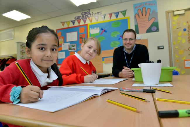 Cutteslowe Primary School pupils Samina Miah, seven, and Wiktoria Rodzik, eight, show off their writing skills with headteacher Jon Gray