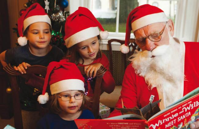 OUP employees' children dress up as elves alongside Santa Mick Busby for the company's 2016 Christmas cards
