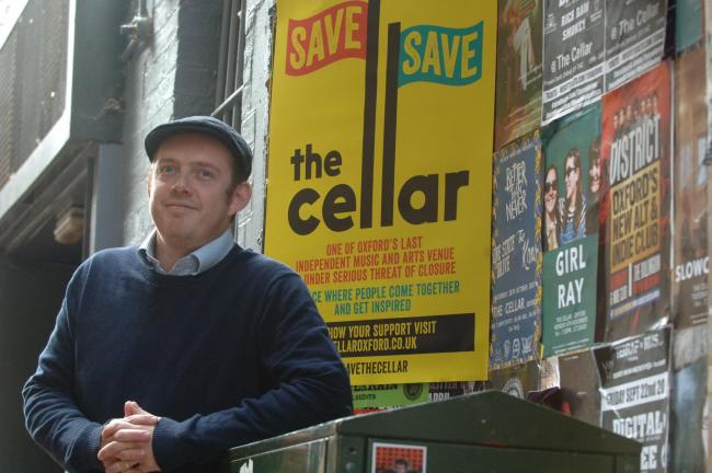 Tim Hopkins, manager of The Cellar, with the poster released in support of the campaign to save the venue. Picture by Tim Hughes