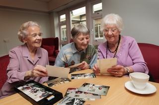 From left, Audrey Jacobs, 86, Frances Nicholl, 85, and Mary Hanna, 84, share memories looking at some photographs